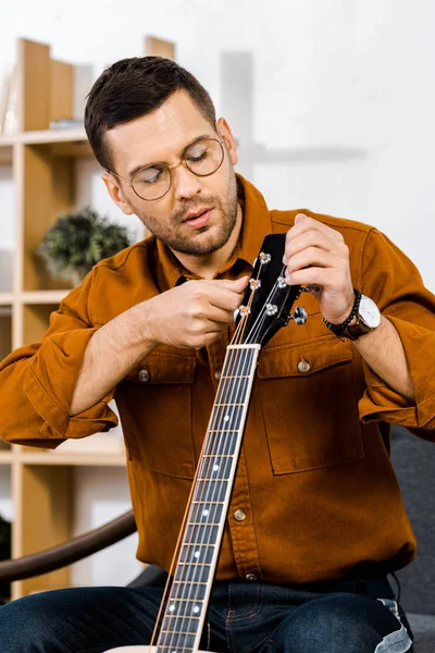 Guapo Hombre Gafas Afinación Guitarra Acústica Casa — Foto de Stock