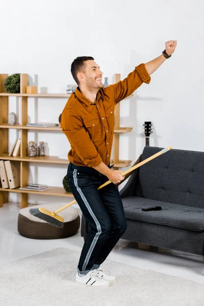 Homem Bonito Divertindo Enquanto Limpando Sala Estar Moderna — Fotografia de Stock