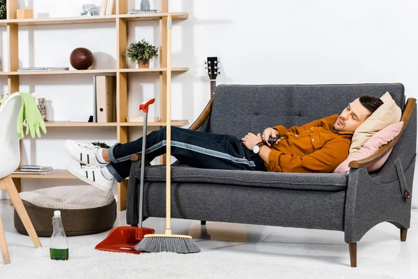 モダンなリビング ルームのソファの上に眠っているハンサムな男 — ストック写真