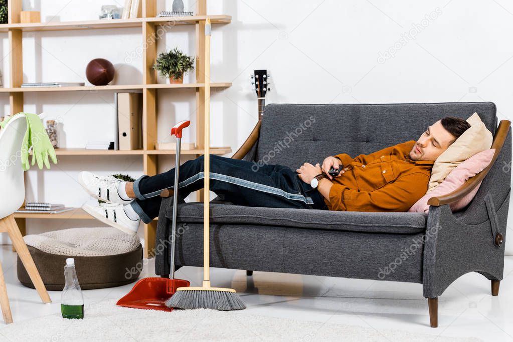 handsome man sleeping on sofa in modern living room 
