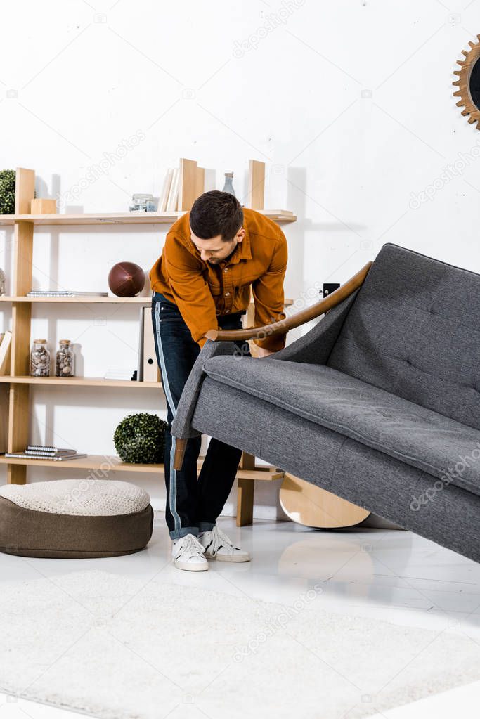 handsome man in modern living room rising sofa