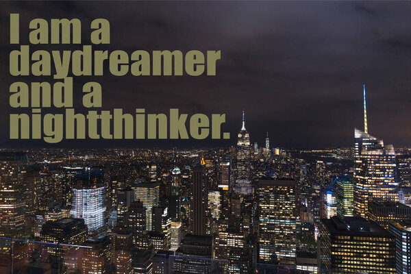 aerial view of buildings and night city lights with "i am a daydreamer and a nightthinker" lettering in new york, usa