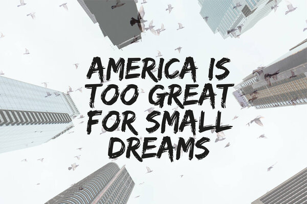 bottom view of skyscrapers and clear sky with birds and "america is too great for small dreams" quote in new york city, usa