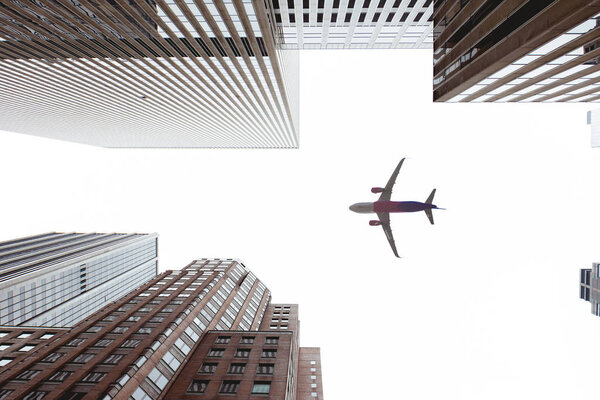 Bottom view of skyscrapers and airplane in new york city, usa