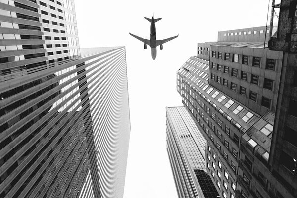 bottom view of skyscrapers and airplane in sky in new york city, usa