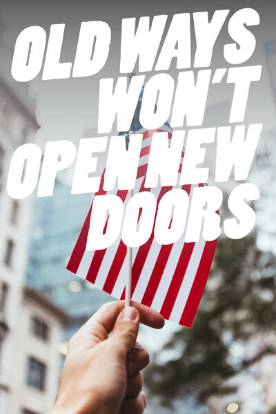 cropped shot of man holding american flag in hand with blurred new york city street on background and "old ways wont open new doors" quote
