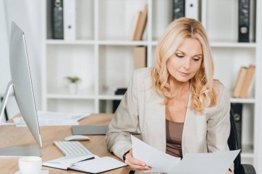 Office belgeleriyle çalışma ve oturma profesyonel iş kadını konsantre 
