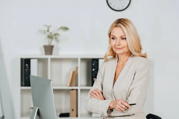 Beautiful Mature Businesswoman Standing Crossed Arms Looking Desktop Computer Office — Stock Photo, Image