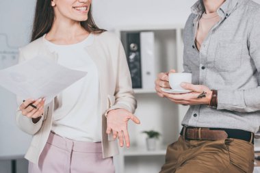kağıtları ve erkek arkadaşı kahve ofiste holding holding gülümseyen iş kadını kırpılmış atış 