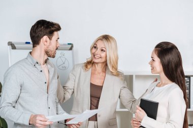 gülümseyen olgun işkadını defter ve belgeleri Office ile genç arkadaşları arıyorum