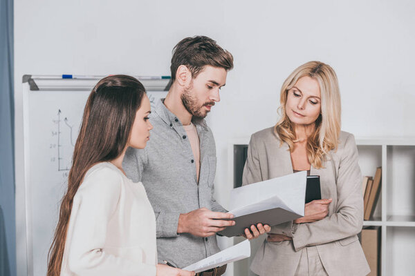 focused professional businesspeople working with documents and discussing project in office 