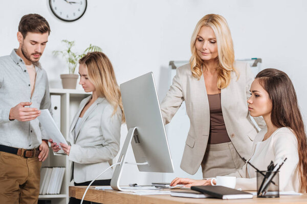 professional businesspeople working with desktop computer and papers in office