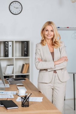 çapraz kolları ile ayakta ve kamera Office gülümseyen güzel olgun iş kadını