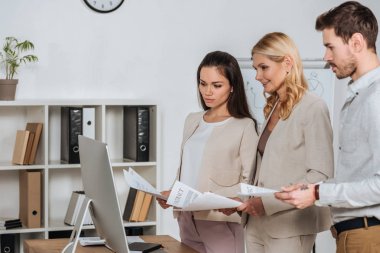 kağıtları tutarak ve masaüstü bilgisayar kullanma office odaklı iş adamları