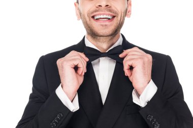 gülümseyen adam siyah smokin ve kravat yay üzerinde beyaz izole poz kırpılmış görünümünü