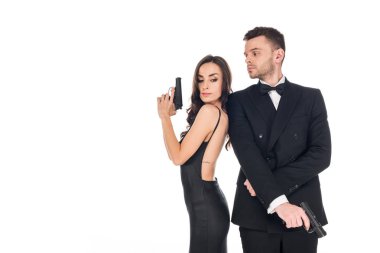 beautiful couple of secret agents in black clothes posing with guns, isolated on white clipart