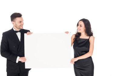 holding beyaz izole boş Yönetim Kurulu, siyah şık giysiler içinde çekici çift