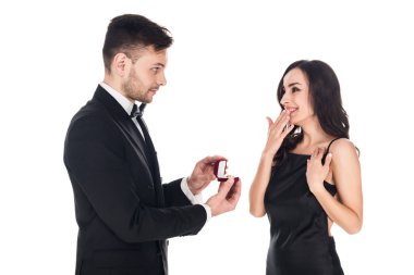 happy boyfriend giving proposal ring in box to surprised girlfriend, isolated on white  clipart