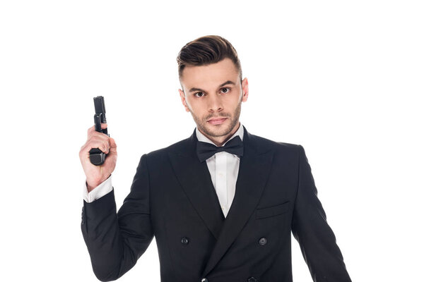 handsome secret agent in black suit and tie bow holding handgun, isolated on white