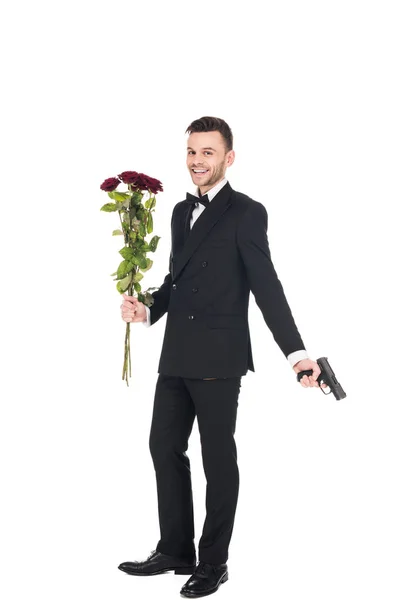 Sorrindo Agente Secreto Terno Preto Segurando Pistola Rosas Vermelhas Isolado — Fotografia de Stock