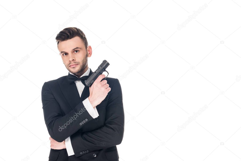 serious secret agent in black suit holding handgun, isolated on white