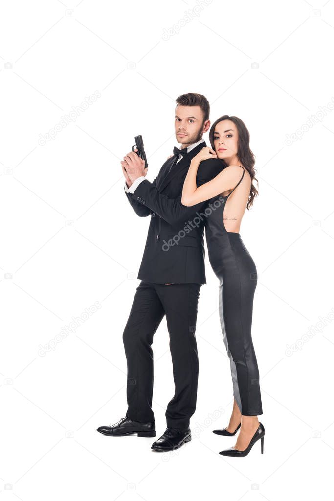 attractive elegant woman hugging male secret agent with gun, isolated on white
