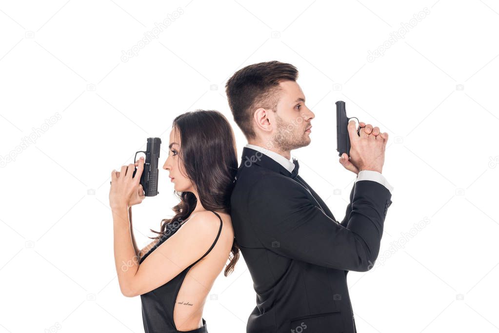 attractive couple of secret agents in black clothes posing with weapon, isolated on white