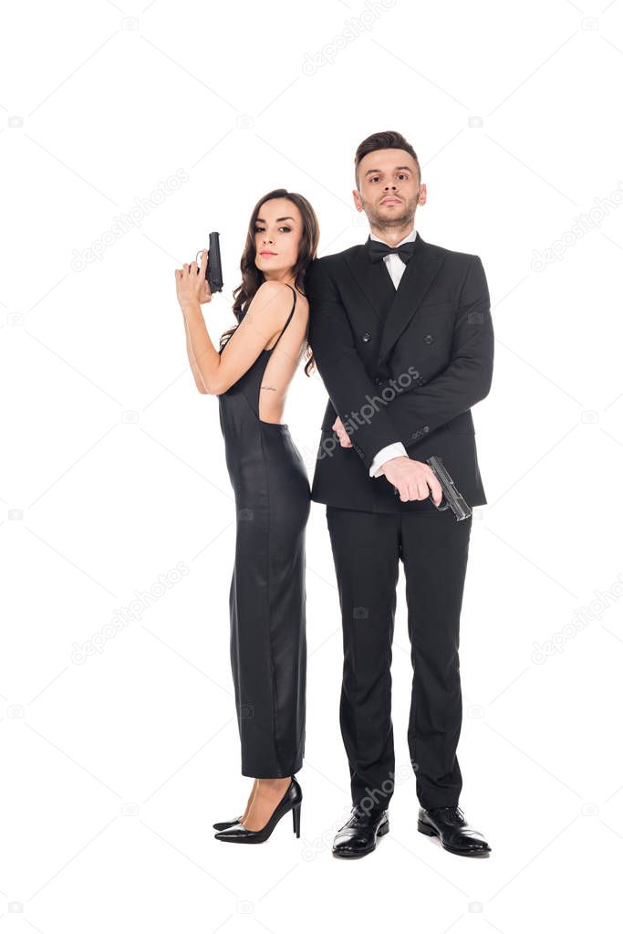 elegant couple of secret agents in black clothes posing with guns, isolated on white