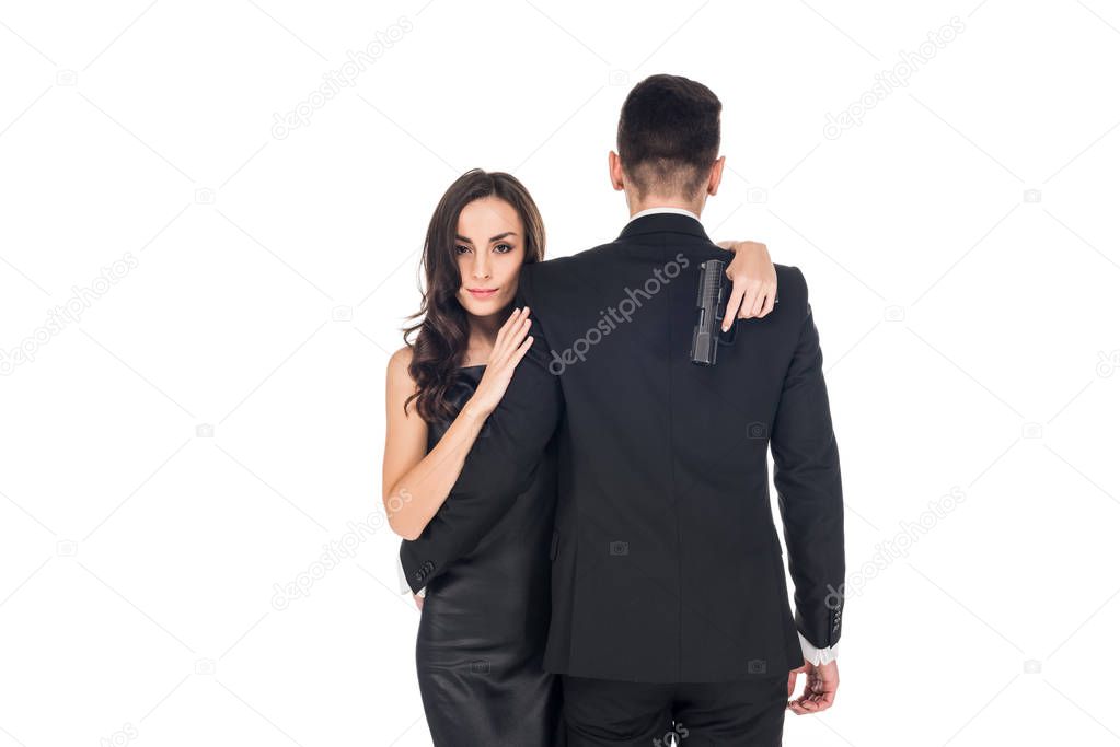 back view of couple of secret agents hugging and holding handgun, isolated on white