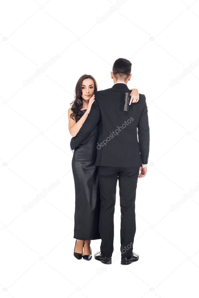 elegant couple of secret agents hugging and holding gun, isolated on white