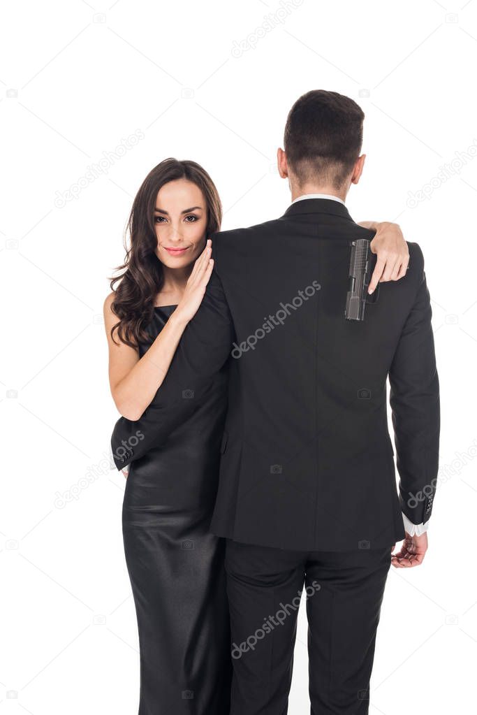 beautiful couple of secret agents hugging and holding handgun, isolated on white