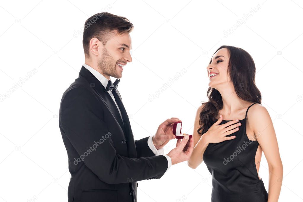 handsome boyfriend giving proposal ring in box to excited girlfriend, isolated on white
