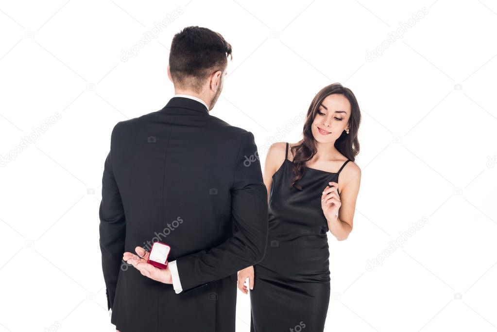 man holding box with proposal ring for girlfriend behind the back, isolated on white