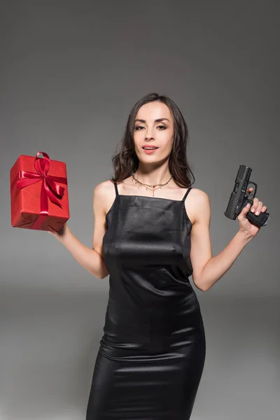 Hermosa Mujer Morena Vestido Negro Sosteniendo Caja Regalo Roja Pistola — Foto de Stock