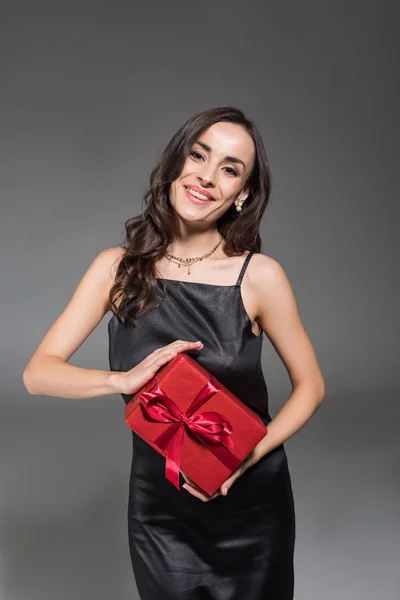 Mooie Lachende Vrouw Met Rode Geschenkdoos Geïsoleerd Grijs — Stockfoto