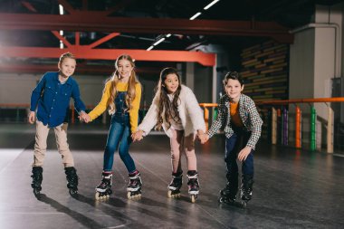 Adorable smiling children preparing to start moving on roller skates  clipart