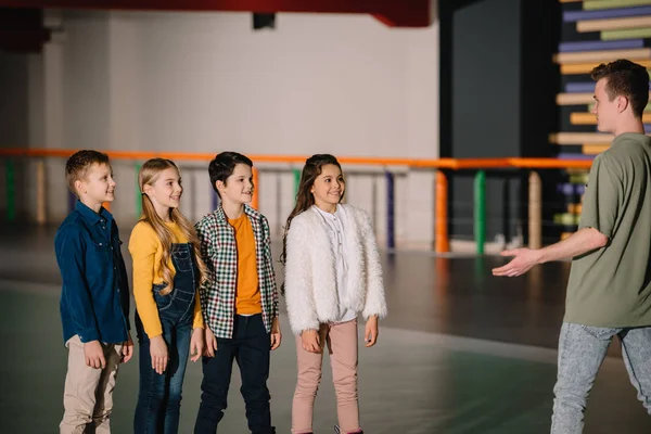 Groupe Enfants Souriants Patins Roulettes Écoutant Les Instructions Entraîneur — Photo