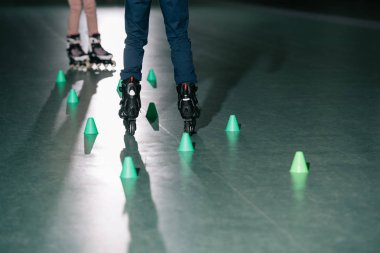 Partial view of preteen roller skaters training together clipart