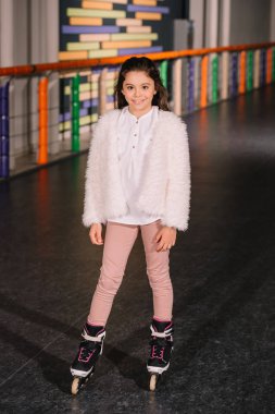 Çok güzel çocuk tekerlekli paten mutlu gülümseyerek poz