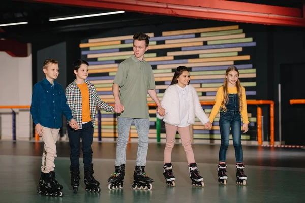 Pretty Smiling Children Handsome Trainer Standing Roller Rink Holding Hands — Stock Photo, Image