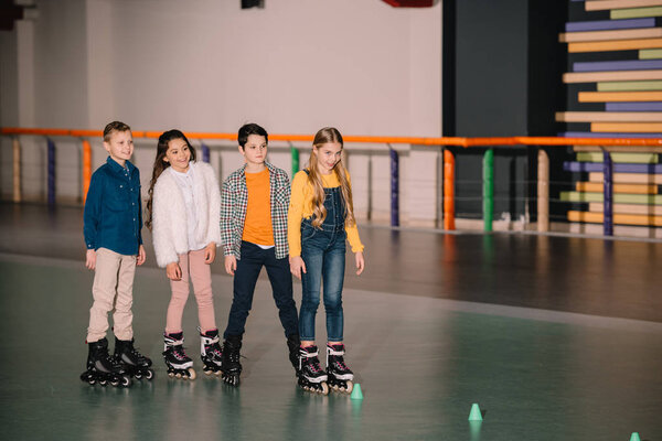 Smiling cute kids ride roller skaters together