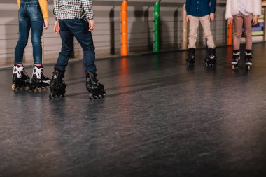 Partial view of preteen roller skaters practicing together clipart
