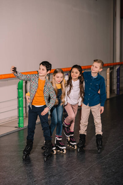 KIds in roller skates making selfie after training on skating rink