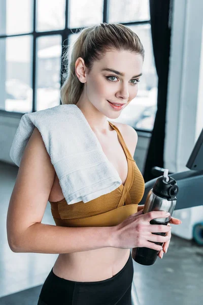 Beautiful Smiling Young Sportswoman Towel Shoulder Holding Sports Bottle Gym — Stockfoto