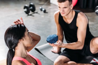 spor salonunda yaralanma muzdarip genç Afro-Amerikan kadın buz paketi veren sporcu