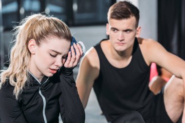 genç sporcu kafa içinde jimnastik salonu için buz torbası koyarak üzgün sportif kız adlı arıyor