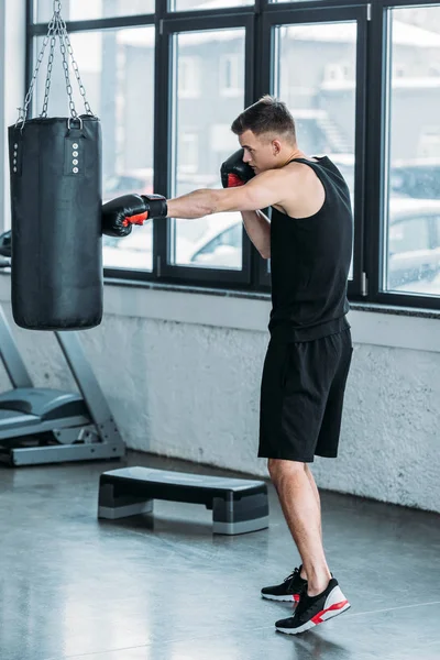 Vista Lateral Jovem Desportivo Homem Boxe Com Saco Perfuração Ginásio — Fotografia de Stock