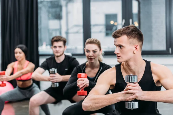 Atletik Genç Erkek Kadınların Spor Salonunda Dumbbells Ile Egzersiz — Stok fotoğraf