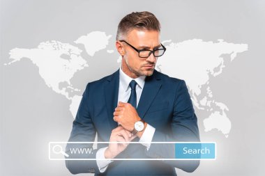 Kol saati takıyor ve dünya harita ve arama çubuğu ile dış görev üzerinde izole gri seyir yakışıklı işadamı