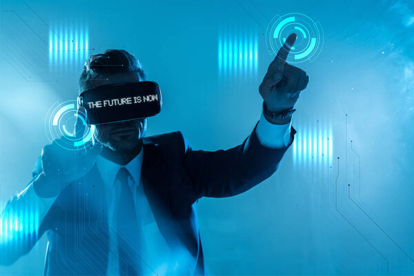 businessman in suit and virtual reality headset with "choose your future" lettering touching something isolated on blue, artificial intelligence concept